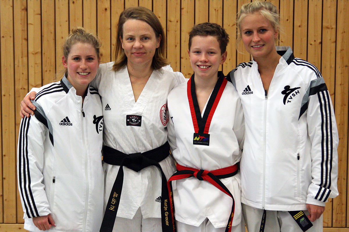Die Bushido-Trainerinnen Kim Berthold (l) und Svea Meyn (r.) freuen sich mit ihren neuen Dan-Trägern Katja Grauer und Leon Rixen.
